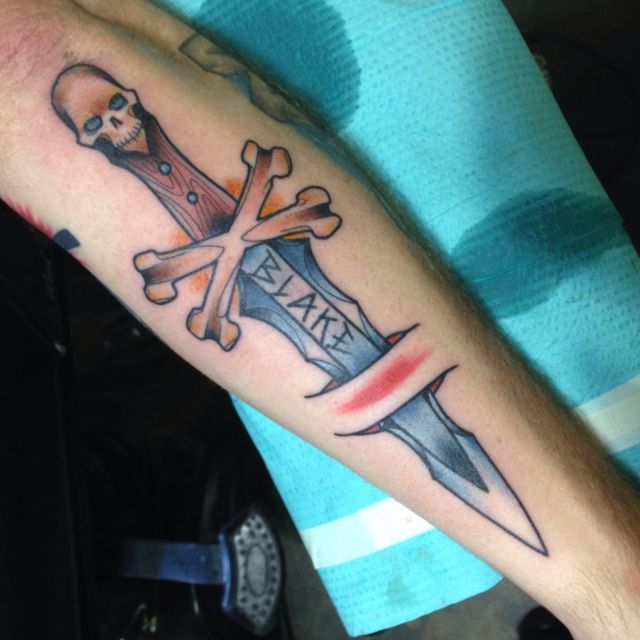 Skull and crossed bones, dagger, cut through, tattoo, on inner forearm. 